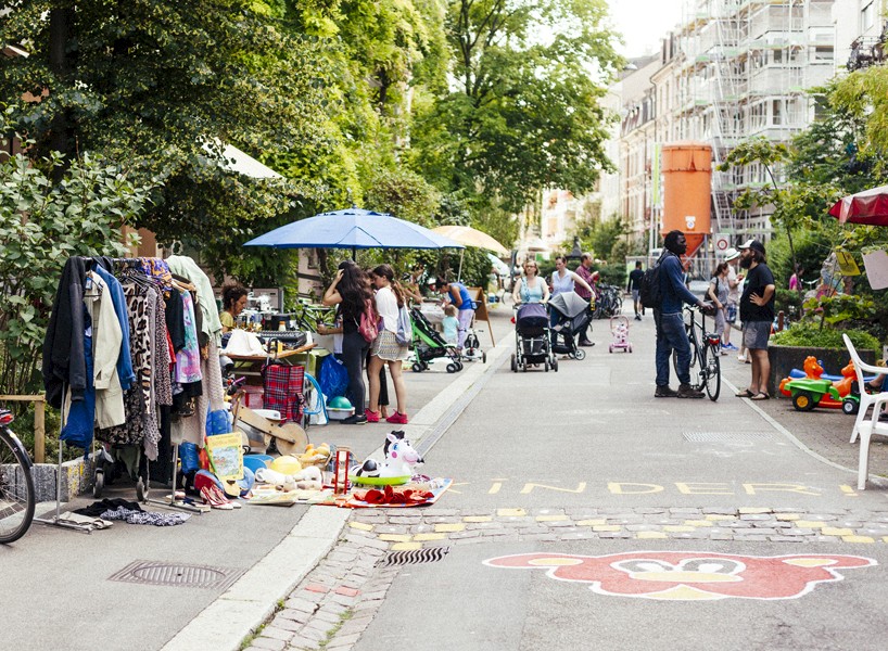 Strasse mit Flohmarktständen und Menschen