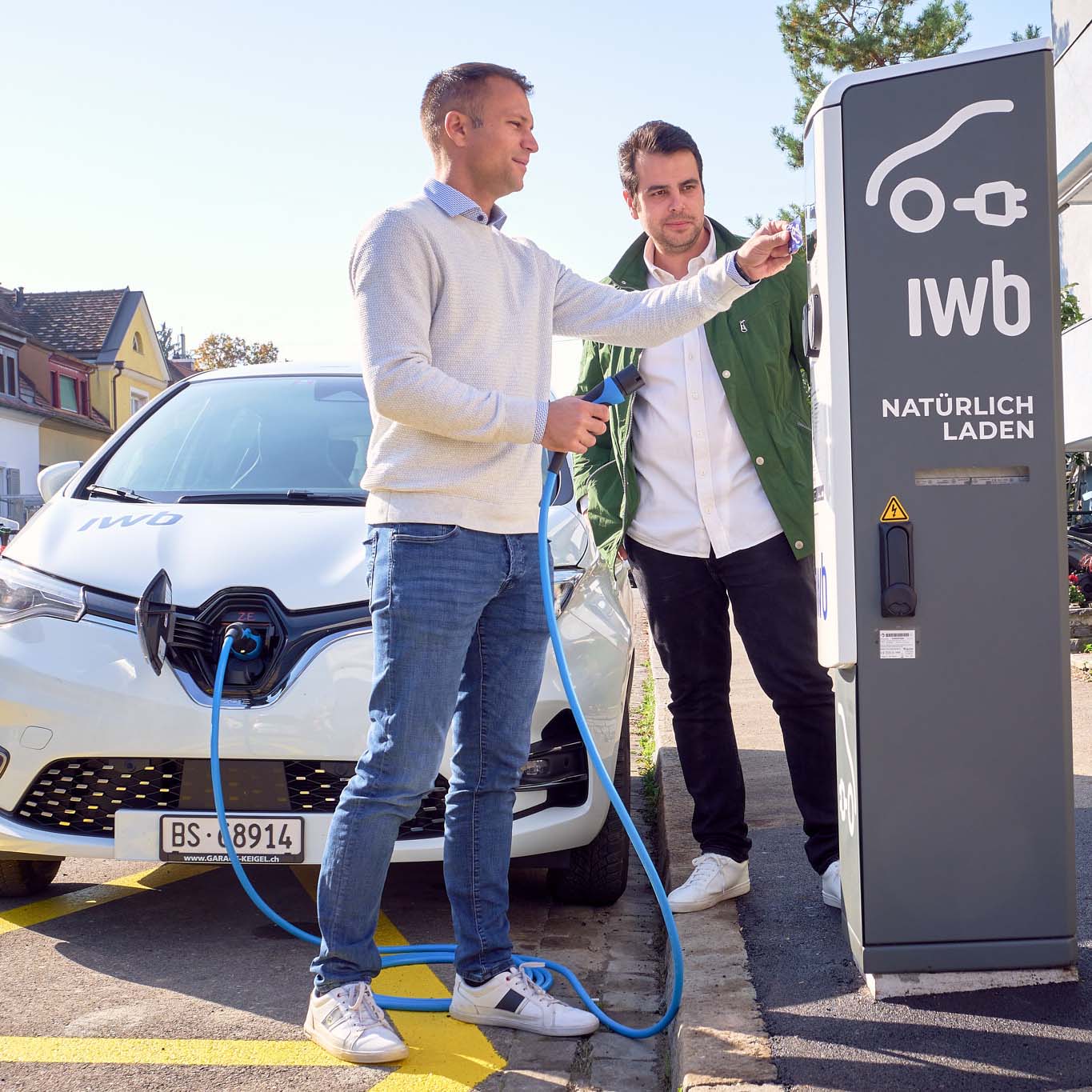 Zwei Männer laden ein Elektroauto in Basel