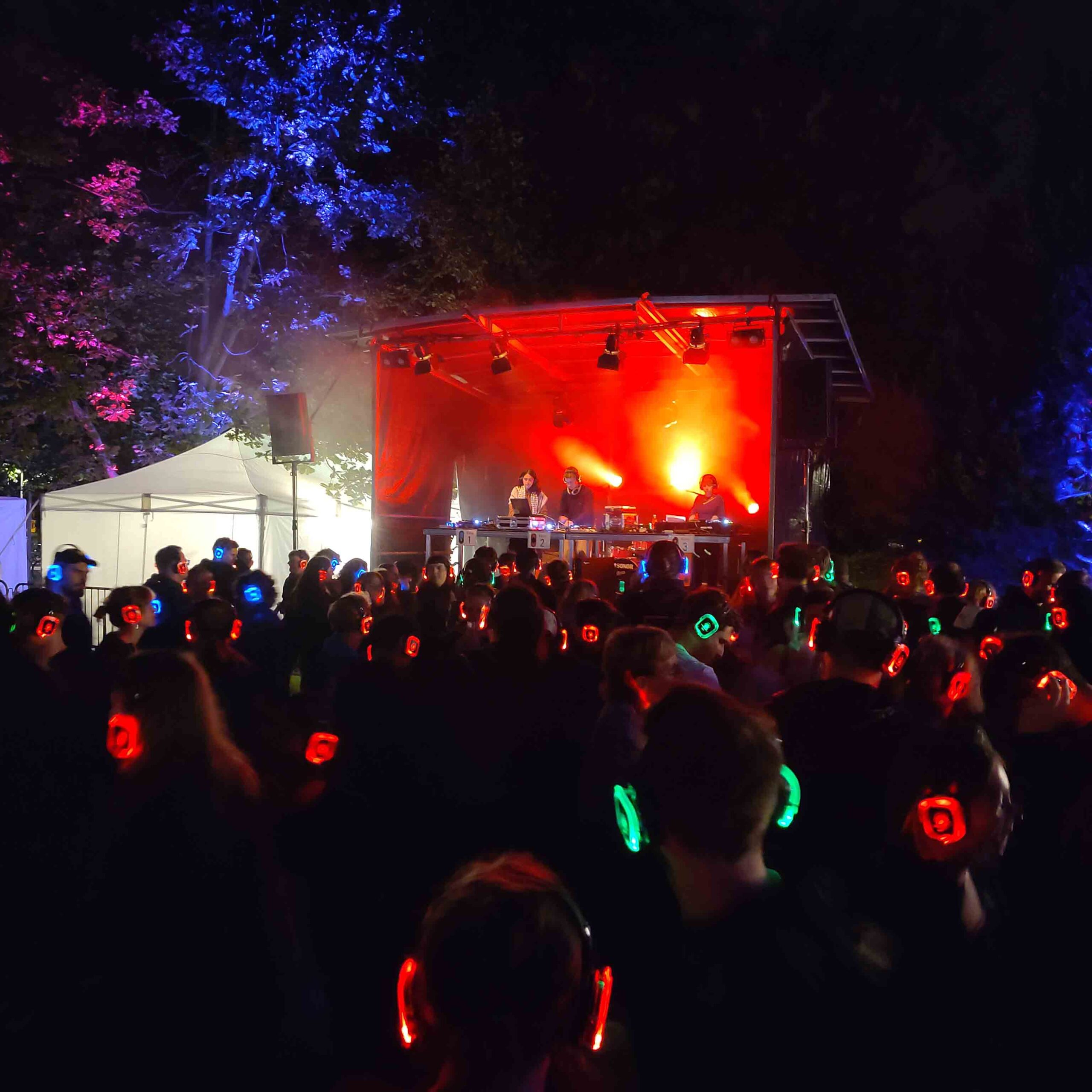 Silent Disco in Basel. Menschen tragen farbige Kopfhörer.