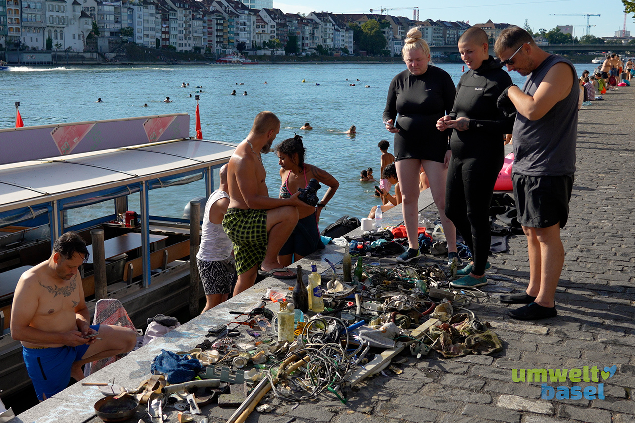 Der gefundene Abfall wird am Rheinufer ausgebreitet.