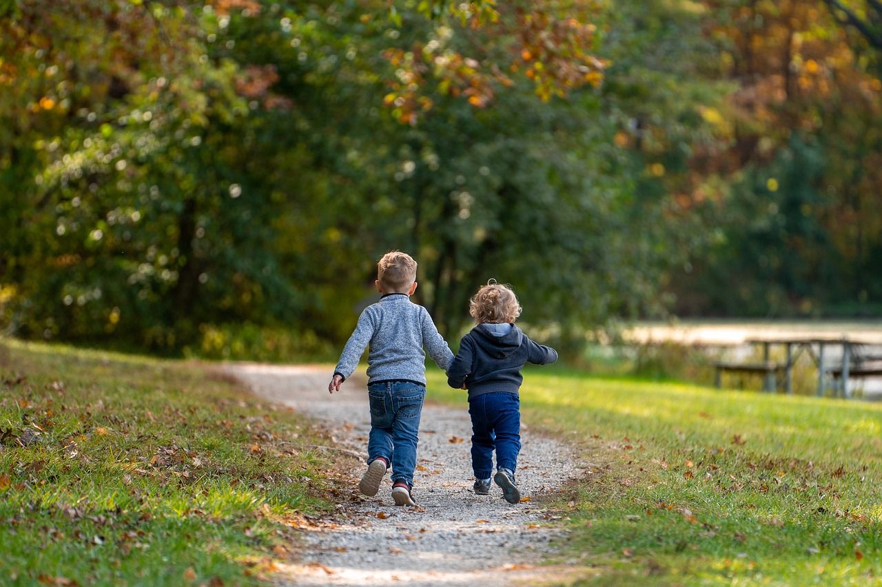 Zwei Kinder rennen in einem Park